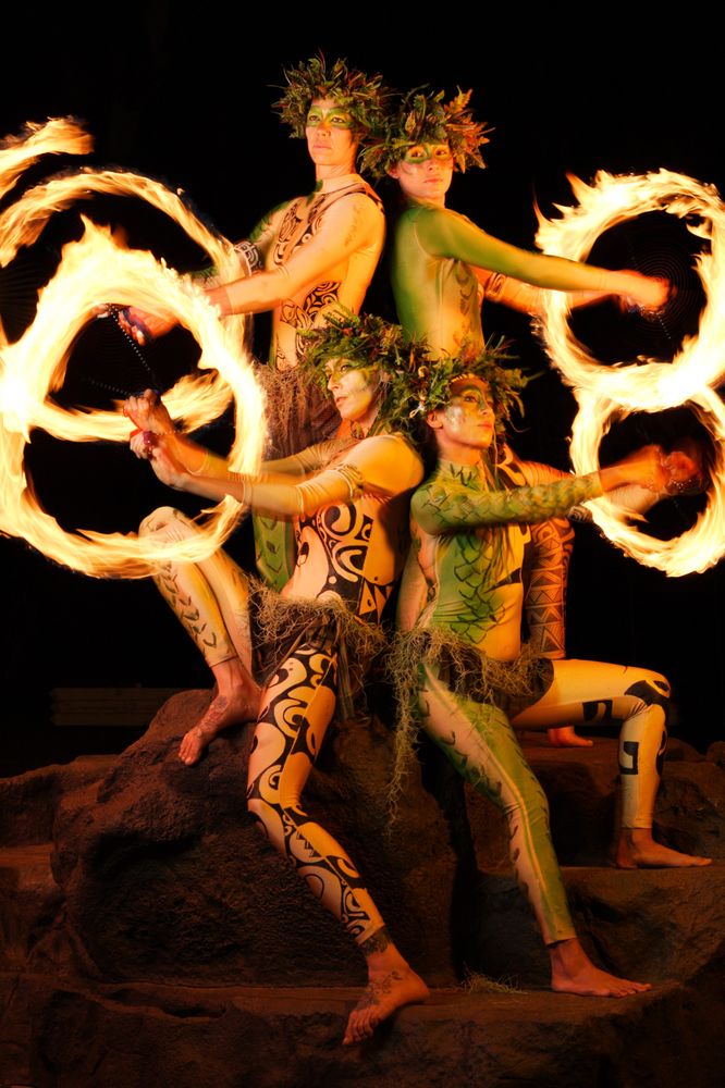 A fire poi ball dancer performing at Lū'au Kalamakū