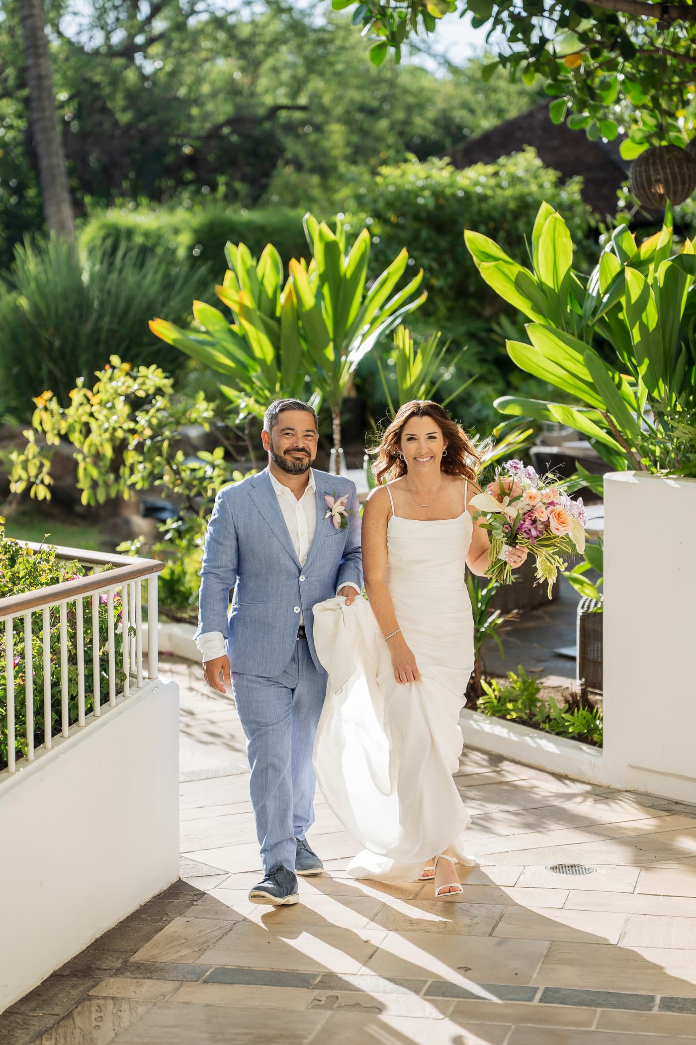 Becca and Jake walking hand in hand through the tropical gardens