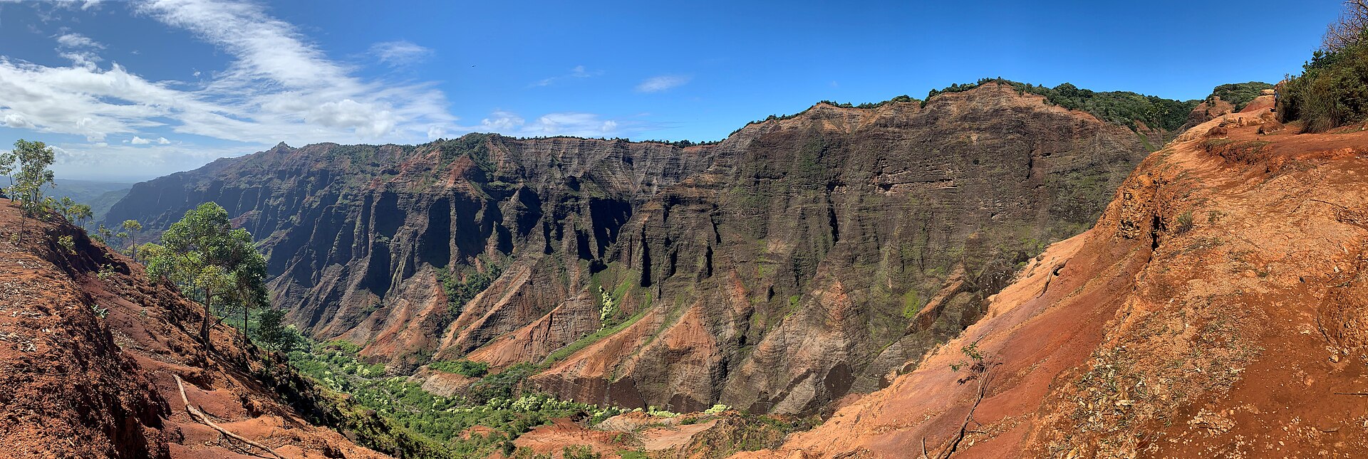 The red and green walls of Waimea Canyon on Kaua'i under scattered cloud
